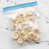 Frozen banana slices in a labeled freezer bag