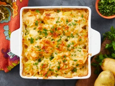 Overhead shot of scalloped potatoes in a white casserole dish.